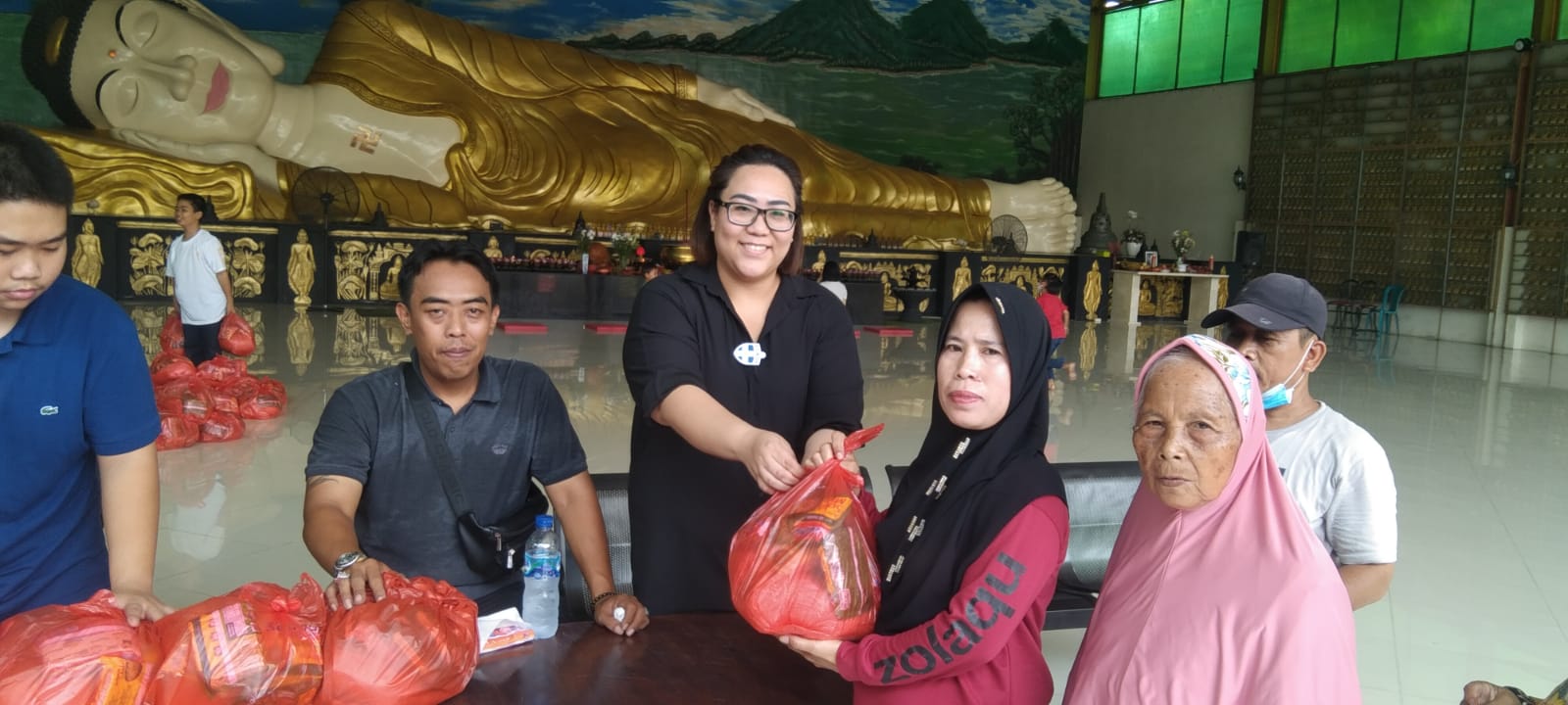 Carren Chaterina SH, MH, CTA, CTL Ketua Yayasan Teratai Kasih Vihara Buddha Dharma & 8 Pho Sat tampak sedang membagikan sembako gratis kepada masyarakat